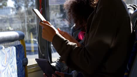 Mother-and-daughter-using-digital-tablet-while-travelling-in-bus-4k