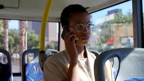 Female-commuter-talking-on-mobile-phone-while-travelling-in-bus-4k