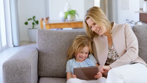 Mutter-Und-Tochter-Nutzen-Digitales-Tablet-Im-Wohnzimmer-4k