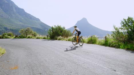 Ciclista-Senior-En-Bicicleta-Por-Una-Carretera-4k