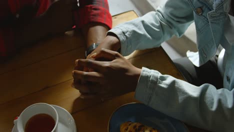 Couple-holding-hands-in-cafe-4k