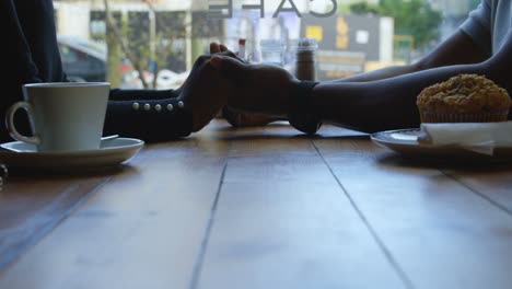 Couple-holding-hands-in-cafe-4k
