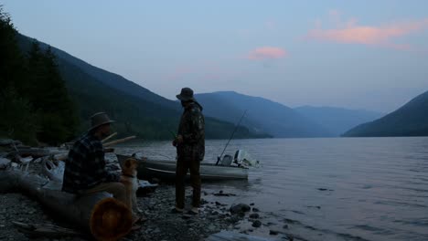 Dos-Pescadores-Interactuando-Entre-Sí-Cerca-De-La-Orilla-Del-Río-4k