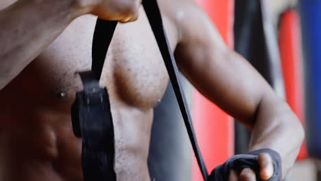 Male-boxer-wearing-hand-wrap-in-fitness-studio-4k