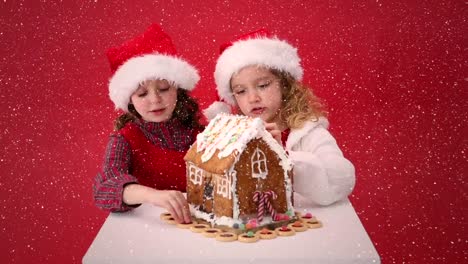 Video-composition-with-falling-snow-over-desk-with-kids-looking-at-ginger-house