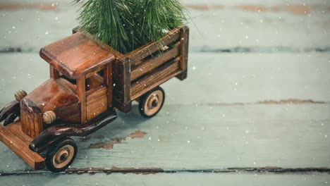 Model-car-with-a-christmas-tree-on-its-load-are-combined-with-falling-snow