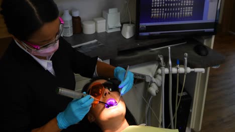 Dentista-Femenina-Examinando-A-Un-Paciente-Con-Herramientas-4k