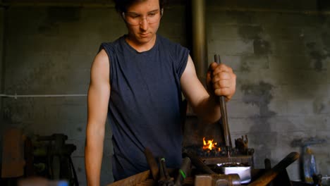 Metalsmith-working-in-workshop-4k