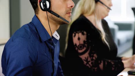 Kundendienstmitarbeiter-Sprechen-Am-Schreibtisch-über-Ein-Headset-In-4K