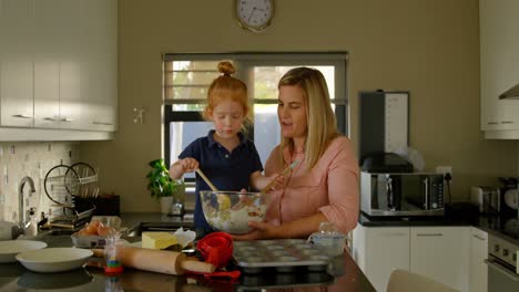 Happy-mother-and-son-mixing-flour-in-kitchen-4k