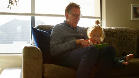 Grandfather-and-grandson-using-digital-tablet-in-living-room-4k