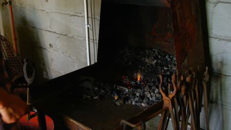 Female-metalsmith-heating-horseshoe-in-fire-4k