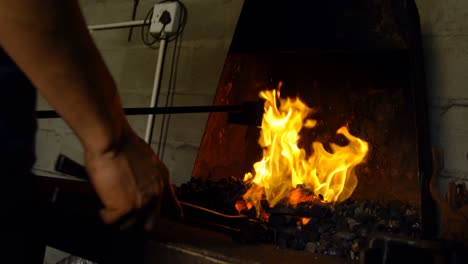 Female-metalsmith-heating-horseshoe-in-fire-4k