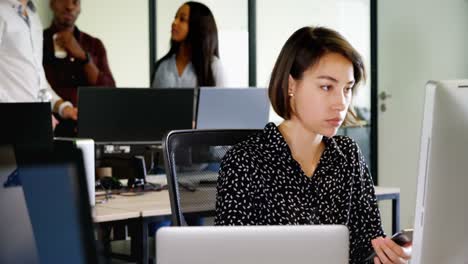 Female-executive-using-mobile-phone-at-desk-4k