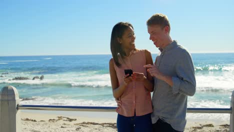 Couple-using-mobile-phone-near-beach-4k