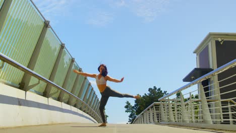 Young-female-dancer-dancing-on-a-bridge-in-the-city-4k