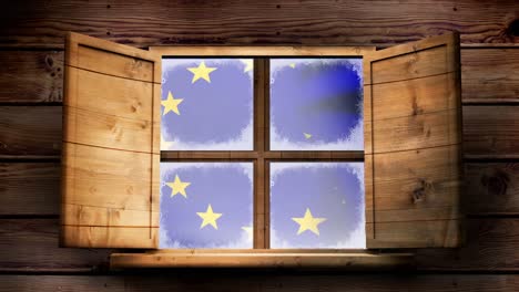 European-flag-floating-through-the-window-of-a-wooden-lodge