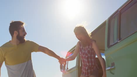 Happy-young-couple-holding-hands-and-getting-out-from-the-van-4k