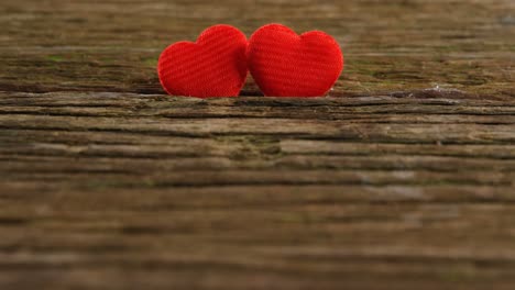 Two-red-hearts-tuck-on-the-wooden-plank-4k