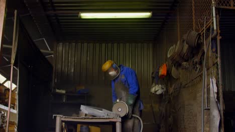Male-worker-using-grinder-machine-in-workshop-4k