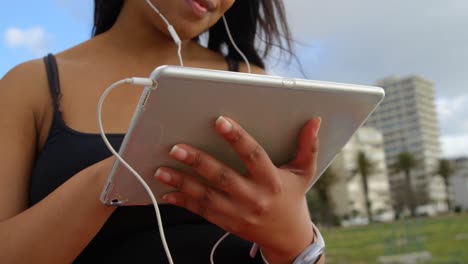 Primer-Plano-De-Una-Mujer-Discapacitada-Escuchando-Música-En-Una-Tableta-Digital-En-El-Parque-4k