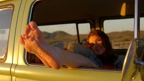 Woman-legs-out-of-the-van-window-during-sunset-4k