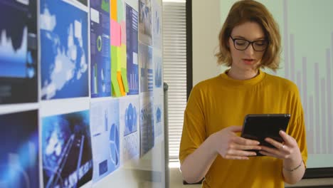 Front-view-of-young-caucasian-businesswoman-looking-at-graphs-in-modern-office-4k