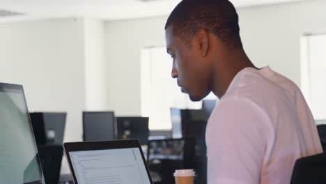 Side-view-of-young-black-male-executive-working-at-desk-in-office-4k