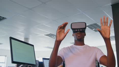 Junge-Schwarze-Männliche-Führungskraft-Nutzt-Virtual-Reality-Headset-Am-Schreibtisch-Im-Modernen-Büro-4k