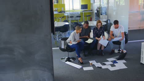 Young-mixed-race-business-team-discussing-over-documents-in-modern-office-4k