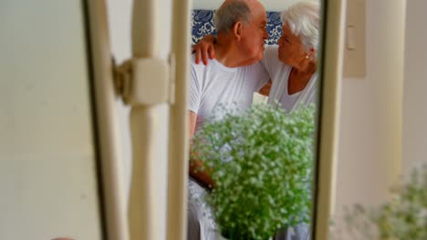 Kaukasisches-Seniorenpaar-Küsst-Sich-Im-Schlafzimmer-Eines-Komfortablen-Zuhauses-4k