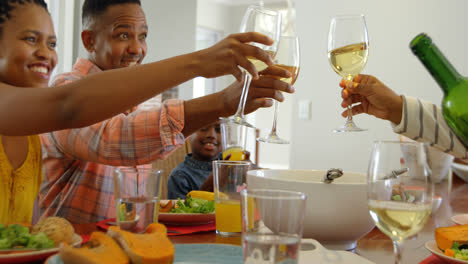 Vista-Lateral-De-Una-Familia-Negra-De-Varias-Generaciones-Comiendo-En-La-Mesa-Del-Comedor-En-Una-Casa-Cómoda-4k