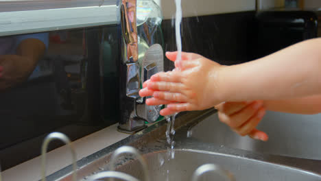 Nahaufnahme-Von-Mutter-Und-Tochter-Beim-Händewaschen-Im-Waschbecken-In-Einem-Komfortablen-Zuhause-4k