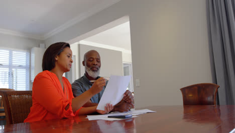 Front-view-of-mature-black-couple-discussing-domestic-bills-in-a-comfortable-home-4k