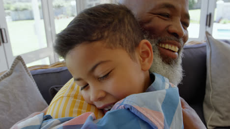 Side-view-of-mature-black-father-embracing-his-son-in-living-room-of-comfortable-home-4k
