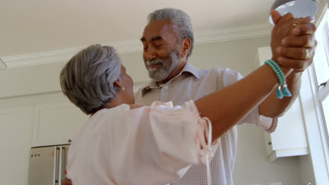 Seitenansicht-Eines-älteren-Schwarzen-Paares,-Das-Gemeinsam-In-Der-Küche-In-Einem-Komfortablen-Zuhause-Tanzt,-4K