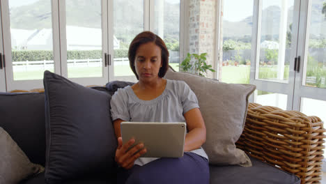 Vorderansicht-Einer-Reifen-Schwarzen-Frau,-Die-Ein-Digitales-Tablet-In-Einem-Komfortablen-Zuhause-Nutzt,-4K