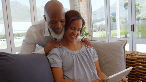 Front-view-of-happy-mature-black-couple-using-digital-tablet-in-a-comfortable-home-4k