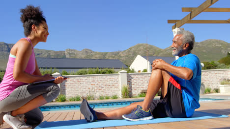 Side-view-of-mixed-race-personal-trainer-exercising-with-determined-senior-black-man-in-backyard-4k