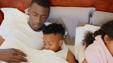 Vista-Frontal-De-Una-Familia-Negra-Durmiendo-En-El-Dormitorio-De-Casa-4k