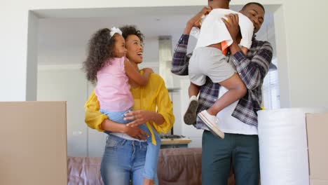 Vorderansicht-Einer-Schwarzen-Familie,-Die-Ihre-Kinder-In-Einem-Komfortablen-Zuhause-Hält,-4K