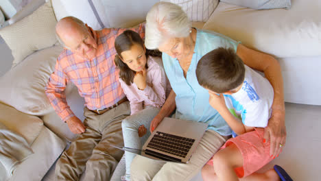 High-angle-view-of-Caucasian-multi-generation-family-using-laptop-in-a-comfortable-home-4k