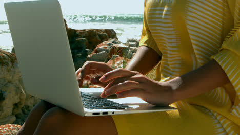 Mittelteil-Einer-Frau,-Die-Am-Strand-Einen-Laptop-Benutzt,-4K