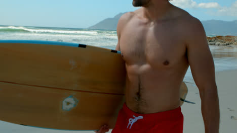 Vorderansicht-Eines-Kuakasischen-Männlichen-Surfers,-Der-Mit-Einem-Surfbrett-Am-Strand-Spaziert,-4k