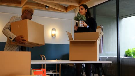 Young-mixed-race-business-colleagues-unpacking-cardboard-boxes-in-modern-office-4k