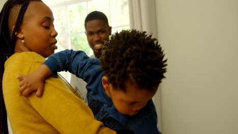 Side-view-of-young-black-mother-holding-her-son-in-a-comfortable-home-4k