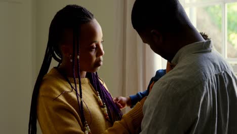 Side-view-of-young-black-parents-holding-their-baby-in-a-comfortable-home-4k