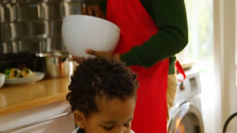 Seitenansicht-Eines-Jungen-Schwarzen-Vaters,-Der-Eine-Schüssel-Hält-Und-Essen-In-Der-Küche-Eines-Komfortablen-Zuhauses-Zubereitet,-4k