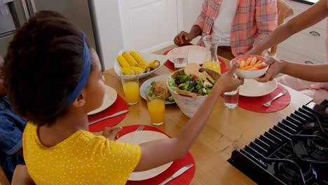Vista-De-ángulo-Alto-De-Una-Familia-Negra-Feliz-Comiendo-Comida-En-Una-Mesa-De-Comedor-En-Una-Casa-Cómoda-4k