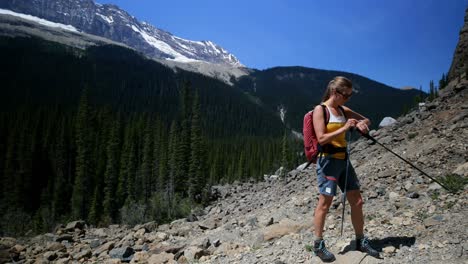 Side-view-of-young-caucasian-female-hiker-with-backpack-hiking-on-mountain-4k